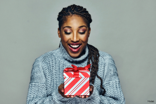 Smiling woman looking at the small gift box in her hands